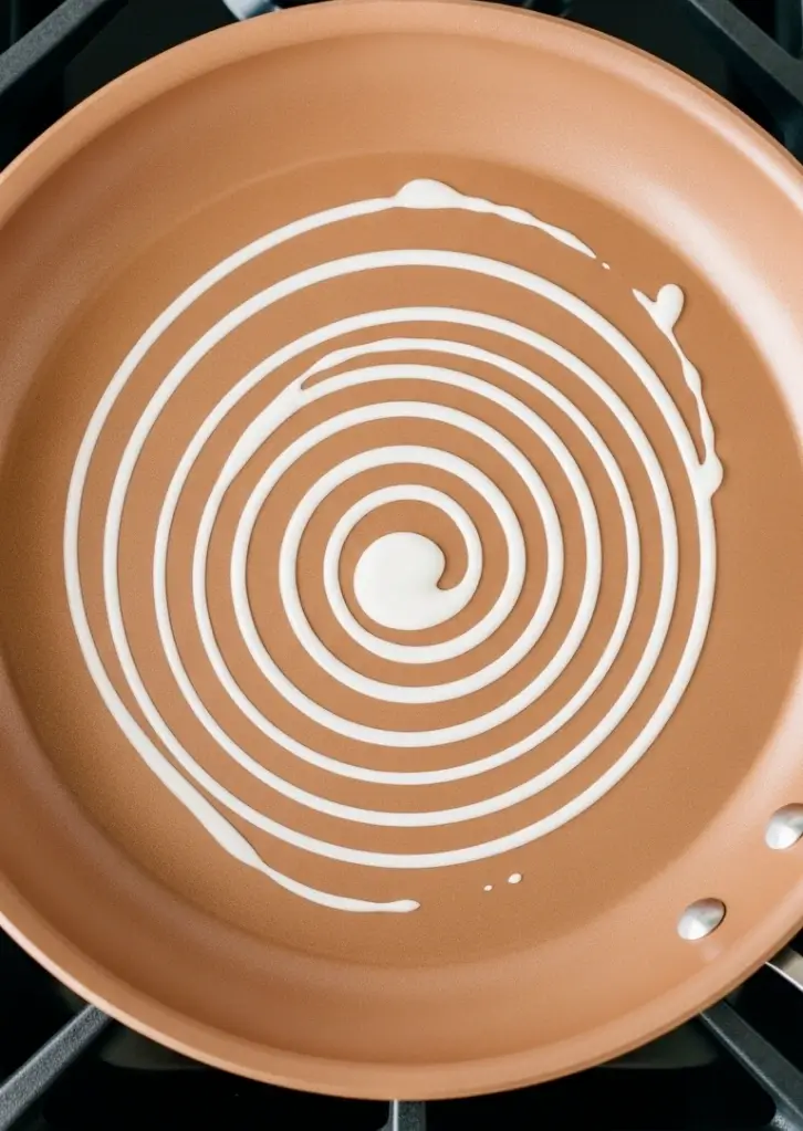 Swirl of kataifi pastry batter in non-stick skillet