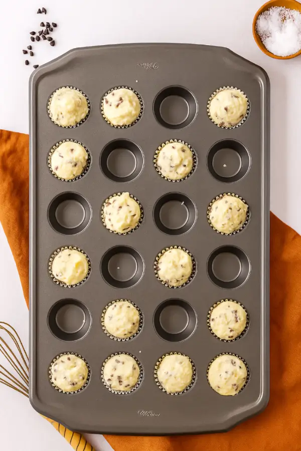 Mini muffin batter portioned into a 24-cup muffin tin