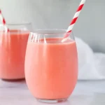 strawberry pineapple smoothie in two glasses on marble counter