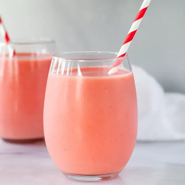 strawberry pineapple smoothie in two glasses on marble counter