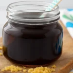Homemade brown sugar syrup in jar with sugar granules