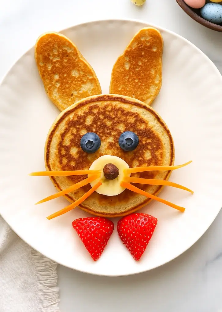 Bunny pancakes with fruit decorations on a white plate