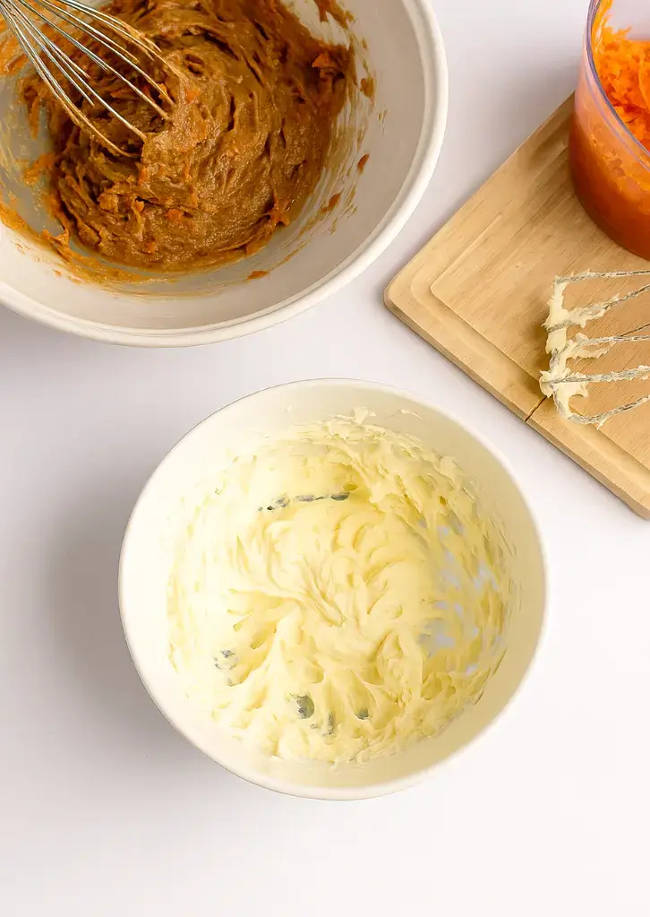 Two bowls with carrot cake batter and cheesecake filling