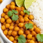 Close-up of Express Chickpea Curry with rice, lime wedges, and cilantro in a white bowl
