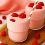 Raspberry-topped cottage cheese smoothie with striped straw