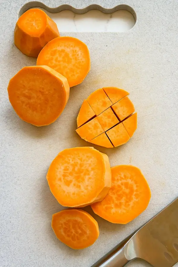 Sweet potatoes sliced and chopped on cutting board