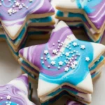 Layered galaxy cookies with purple, teal, and white marbled icing