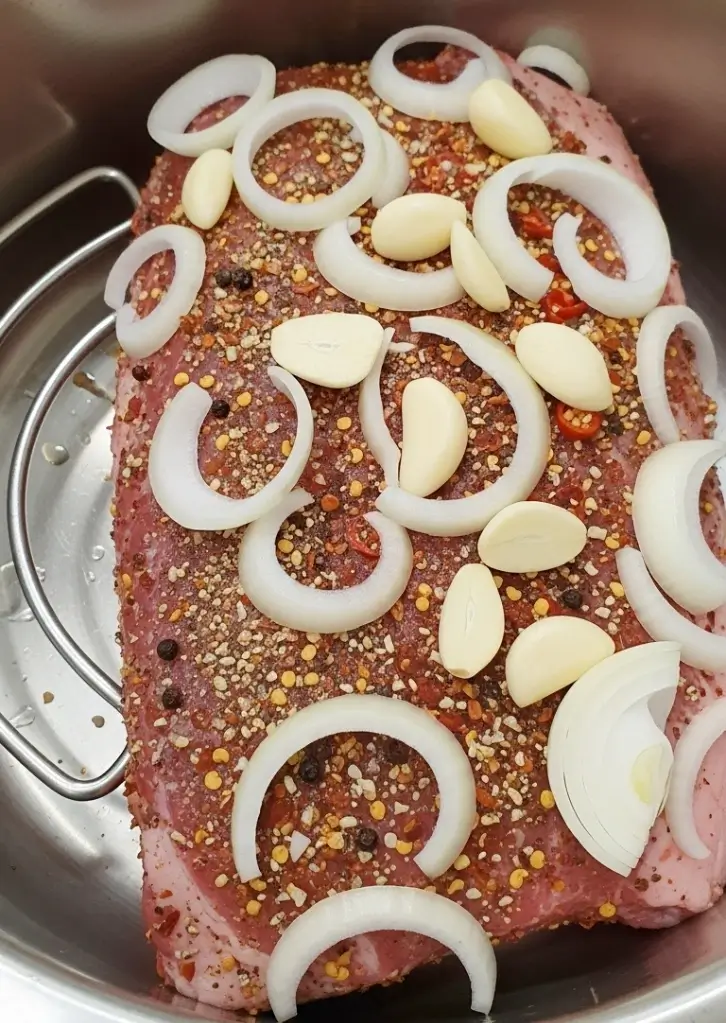 Instant Pot Corned Beef topped with garlic and onion before cooking