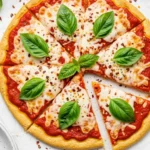 Sliced baked keto pizza with basil on top