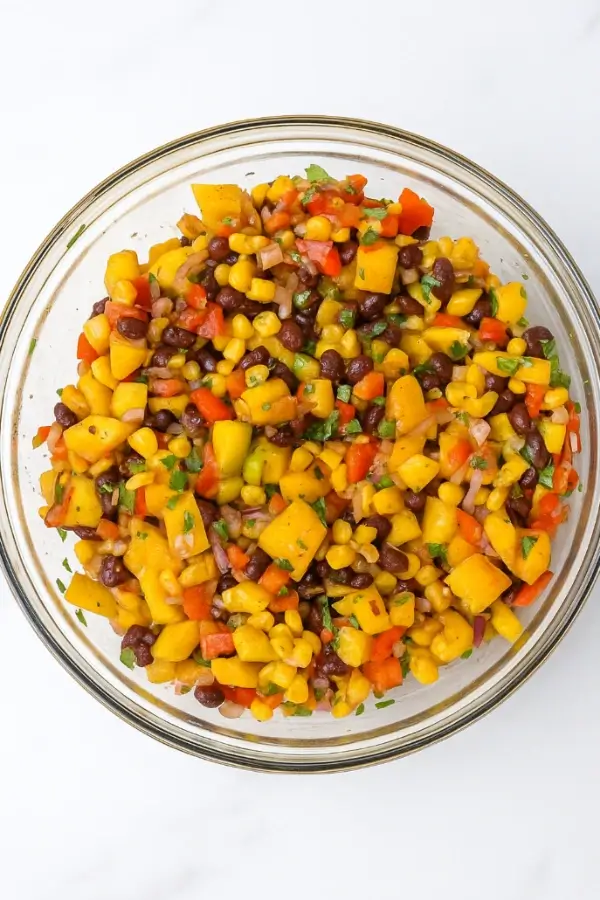 Mixed mango black bean salad in a glass bowl, ready to serve