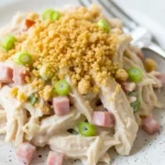 Creamy Neiman Marcus Chicken Casserole topped with crushed crackers and green onions