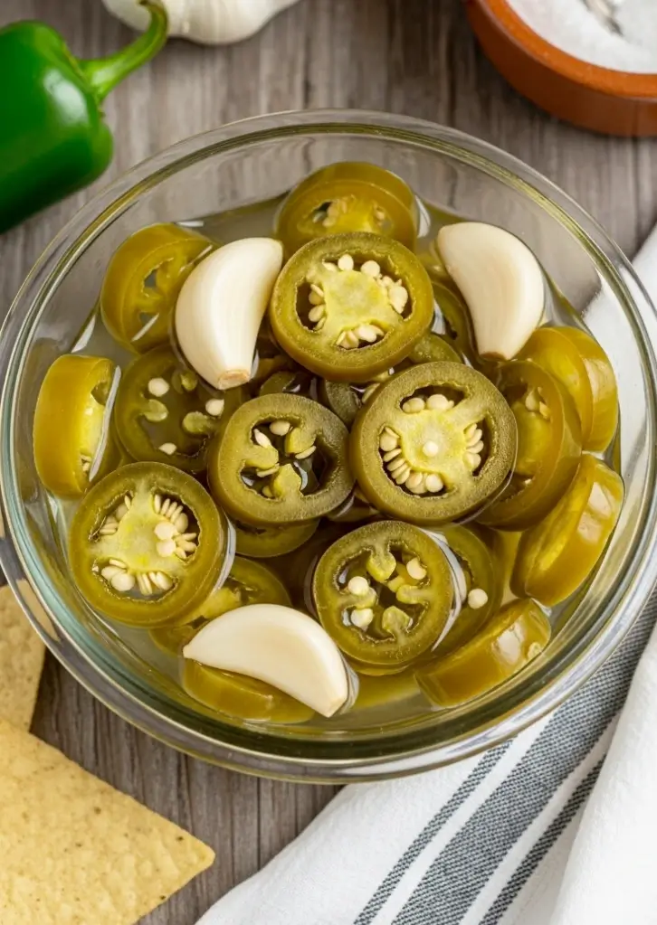 Finished pickled jalapeños with garlic cloves in brine