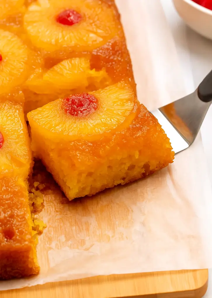 Pineapple upside down cake being sliced and served