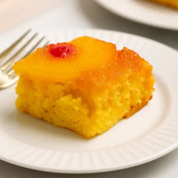 Single slice of pineapple upside down cake on white dish