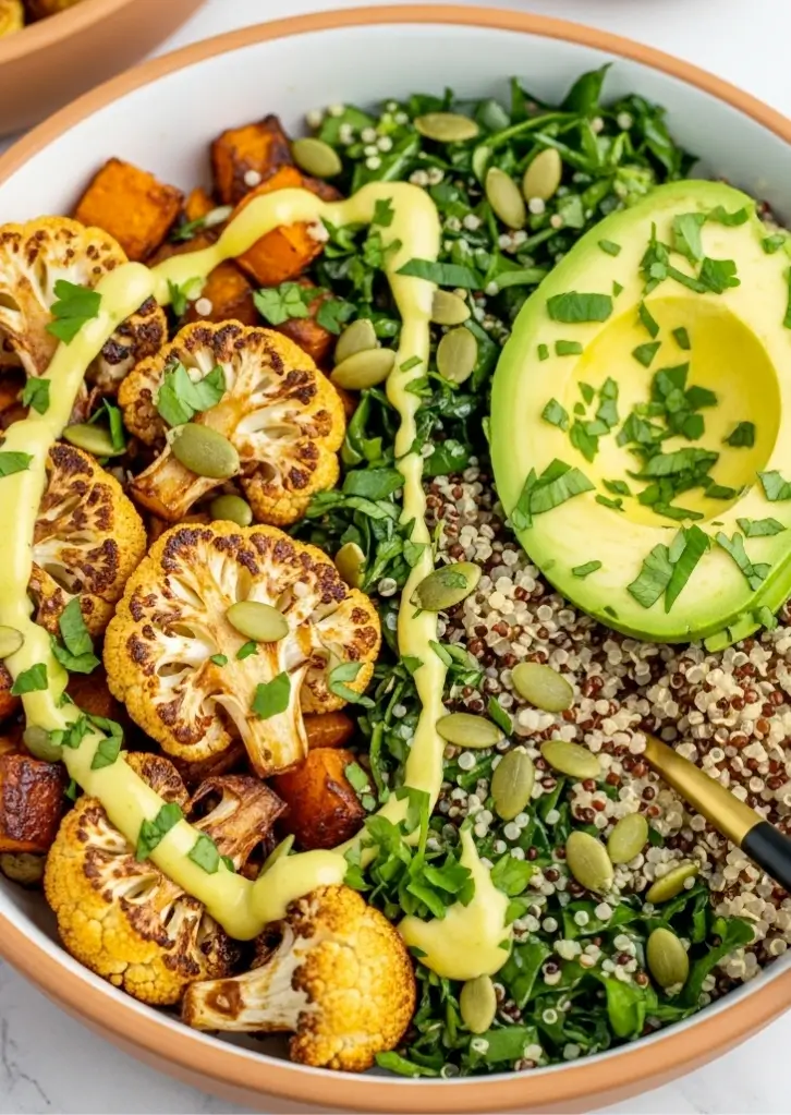roasted veggie bowl with quinoa, avocado, roasted cauliflower, and golden tahini drizzle