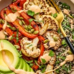 roasted veggie bowl with quinoa, red bell peppers, cauliflower, avocado, and tahini dressing