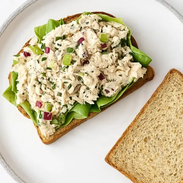 tuna salad sandwich on plate with lettuce