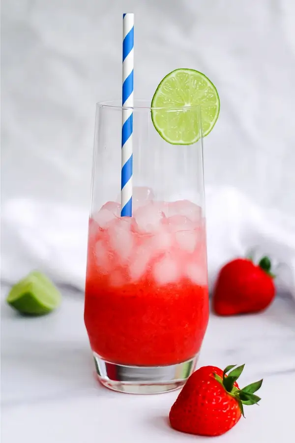 Layered strawberry mocktail with ice and lime