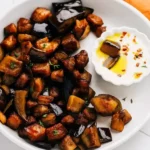 Air fryer eggplant served with dip on white plate