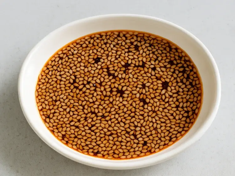 Bowl of Korean-style sesame soy dressing with floating sesame seeds
