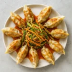 Plated Bibim Mandu with dumplings arranged in a ring around vegetable salad