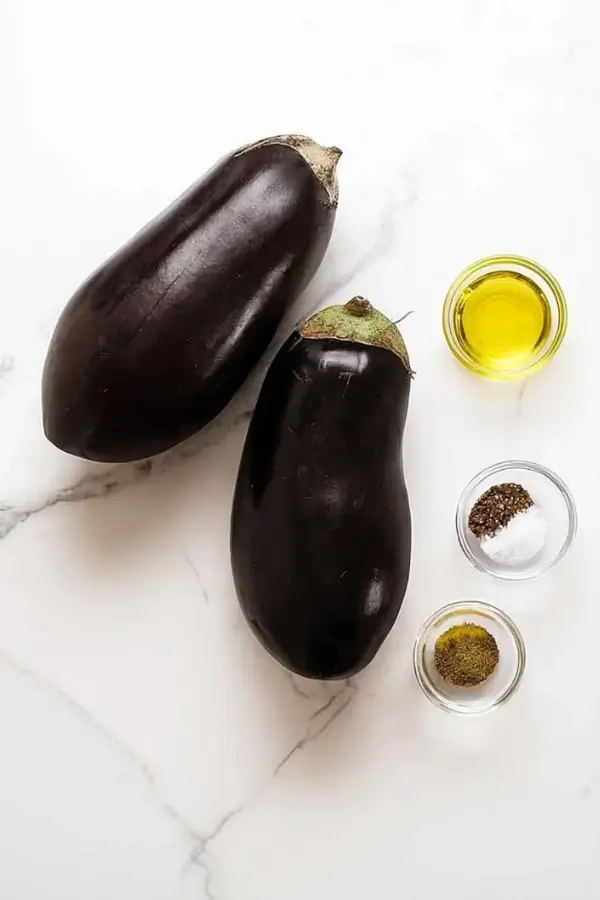 Whole eggplants with olive oil, salt, pepper, and thyme for roasting