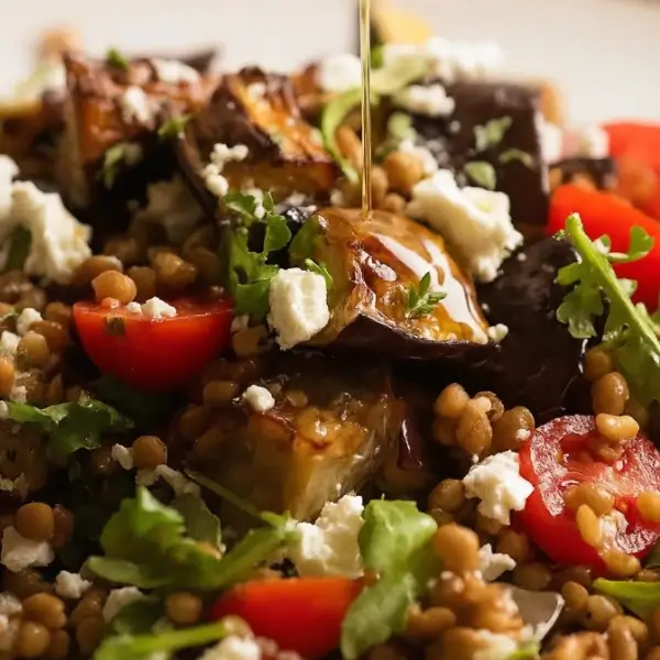 Close-up of lentil and roasted eggplant salad with dressing drizzle