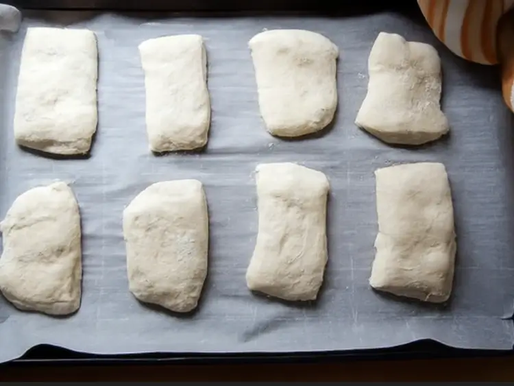 Shaped ciabatta dough resting on a parchment-lined baking tray