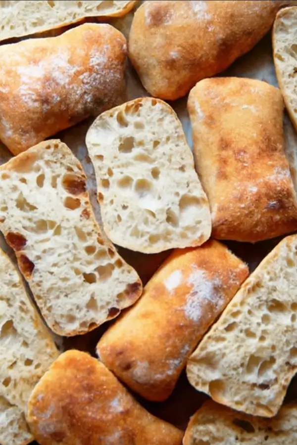 Close-up of multiple ciabatta rolls with open crumb slices