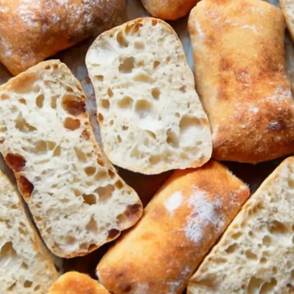 Close-up view of sliced ciabatta rolls showing open crumb and crispy exterior