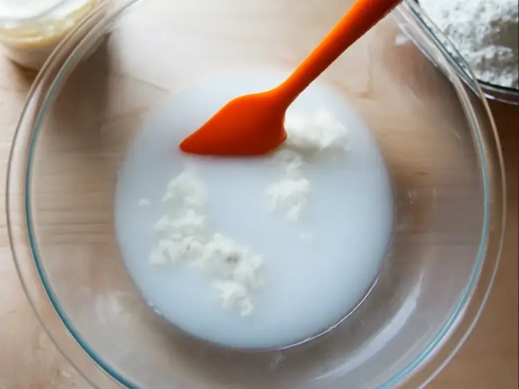Mixing sourdough starter and water for ciabatta dough